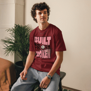 Man wearing the Built From Broken t-shirt in red – streetwear design featuring bold typography and shattered effect